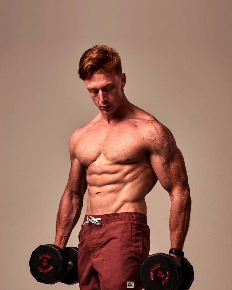 Vincent Gerbert in 2022, gespierd en met twee dumbbells in de fotostudio van Men's Health